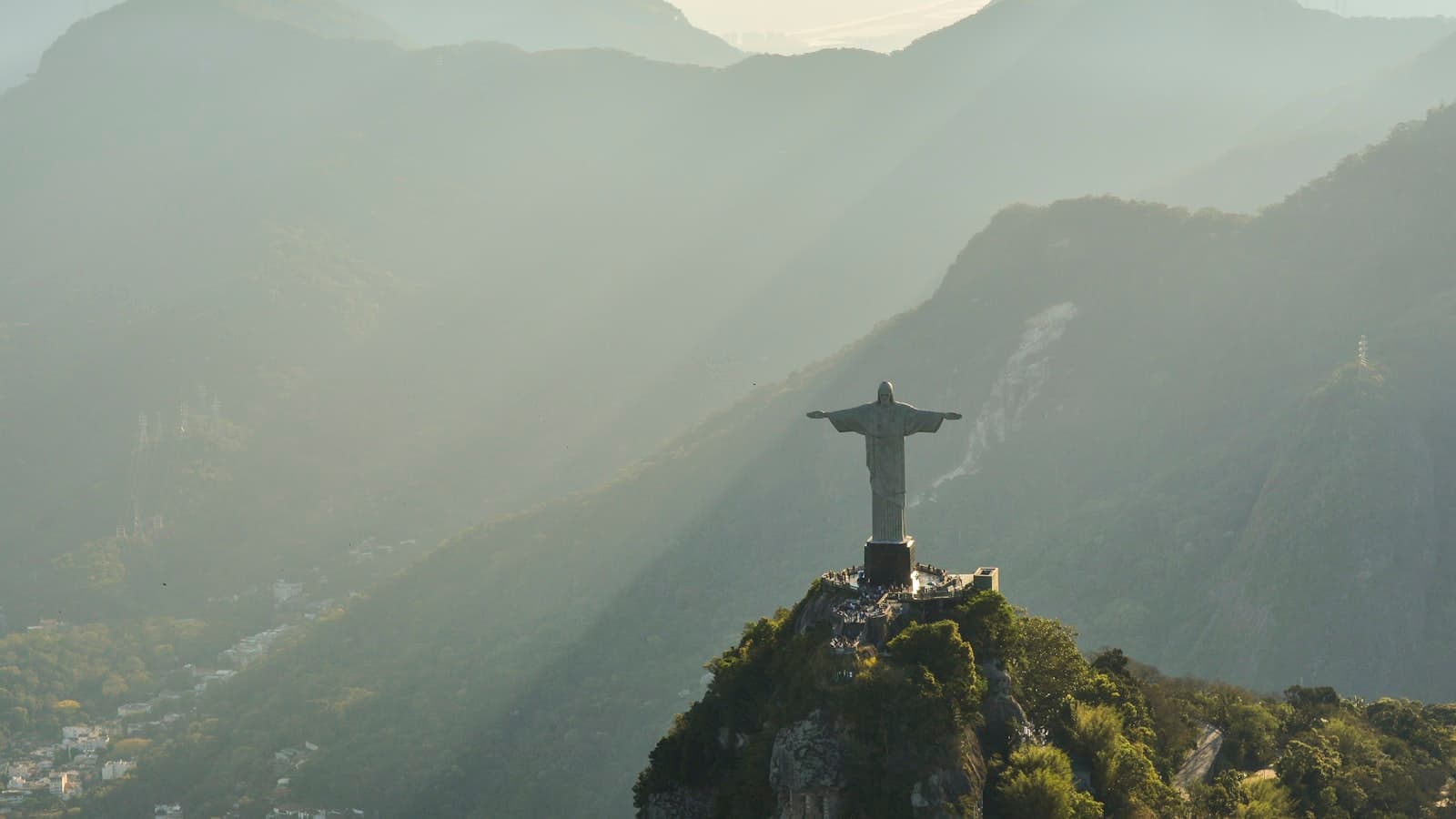 Cristo Redentor visto do alto, com a Floresta da Tijuca e bairros do Rio de Janeiro ao fundo